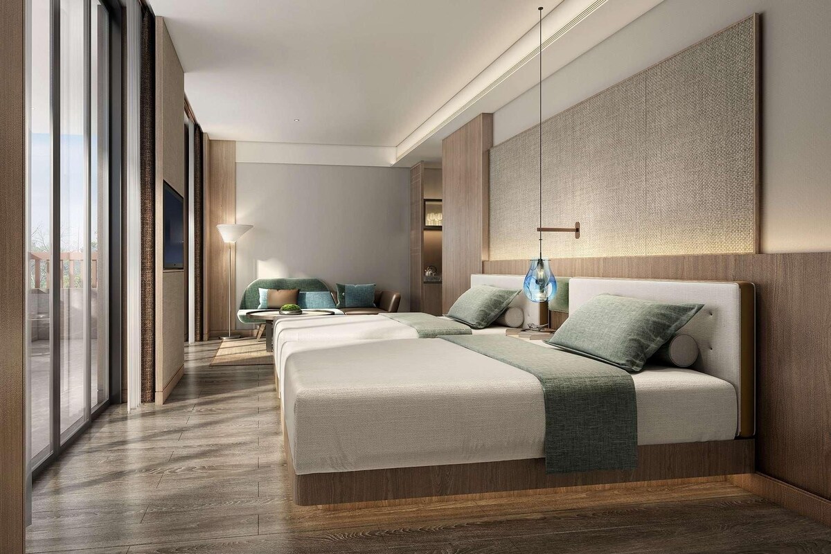 Una habitación de hotel moderna con una cama grande, un sofá y una zona de comedor.
