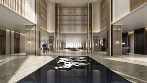 A spacious lobby with a central water feature, high ceilings, and modern lighting. - Wingate by Wyndham Hainan Chengmai (Chengmai)