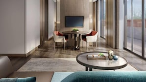 A modern interior with a dining area featuring a round table and chairs, a sofa with a throw pillow, and a coffee table with decorative items. - Wingate by Wyndham Hainan Chengmai (Chengmai)