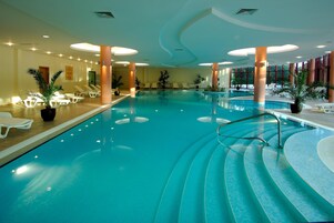 Una piscina techada, una piscina al aire libre de temporada, sombrillas