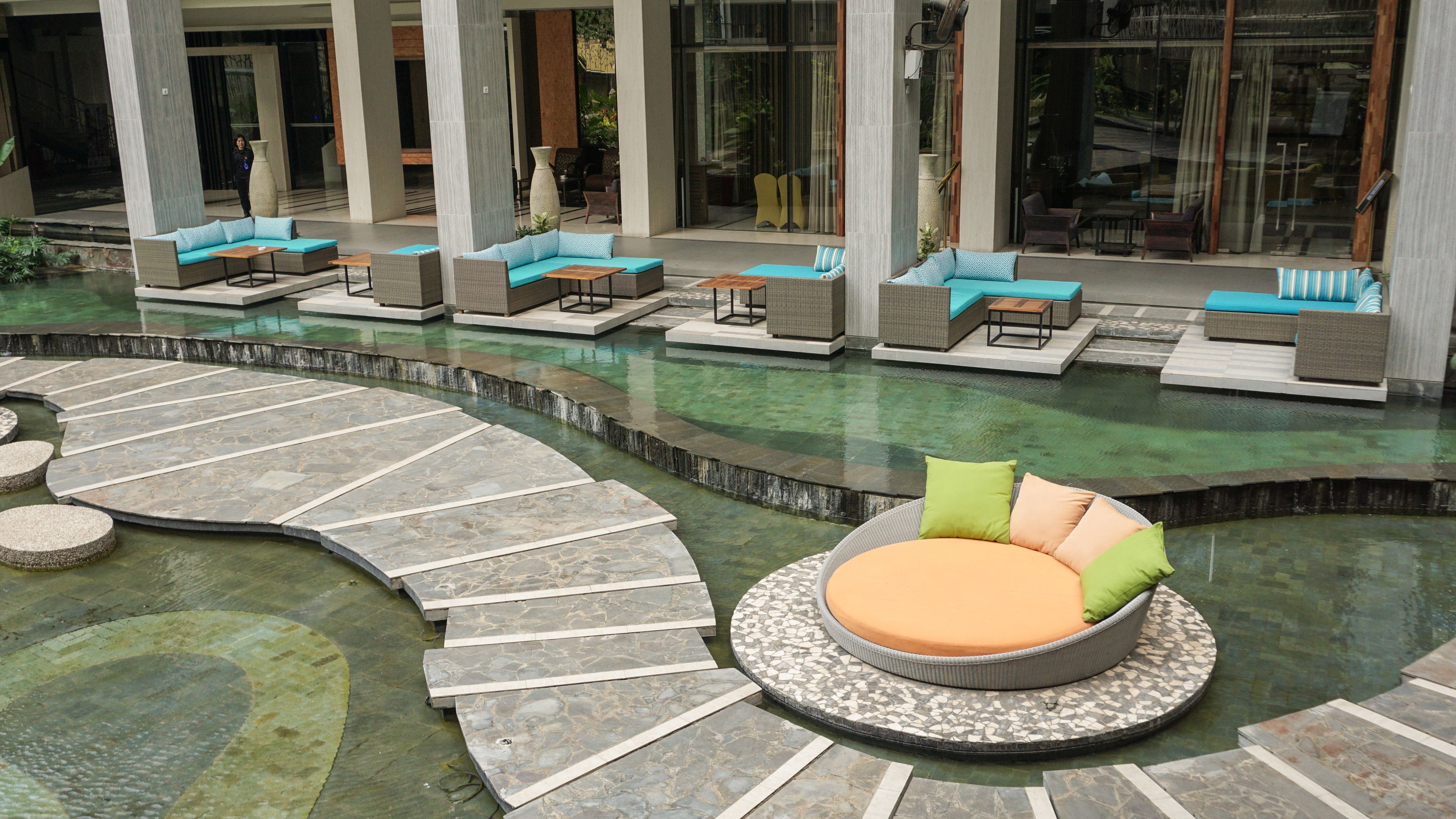 A poolside area with seating arrangements and a circular water feature.