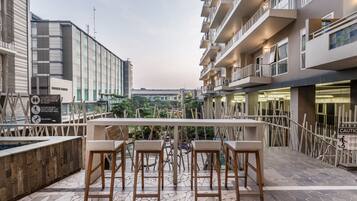 A rooftop terrace with outdoor seating and a view of the cityscape.