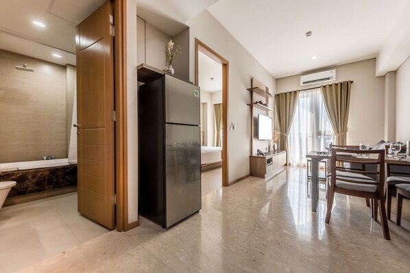 Una habitación de hotel moderna con cocina, comedor y baño.