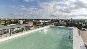 A rooftop pool with a city view, surrounded by buildings and a clear sky. - Bright Stylish in Barrio Jara (Asunción)