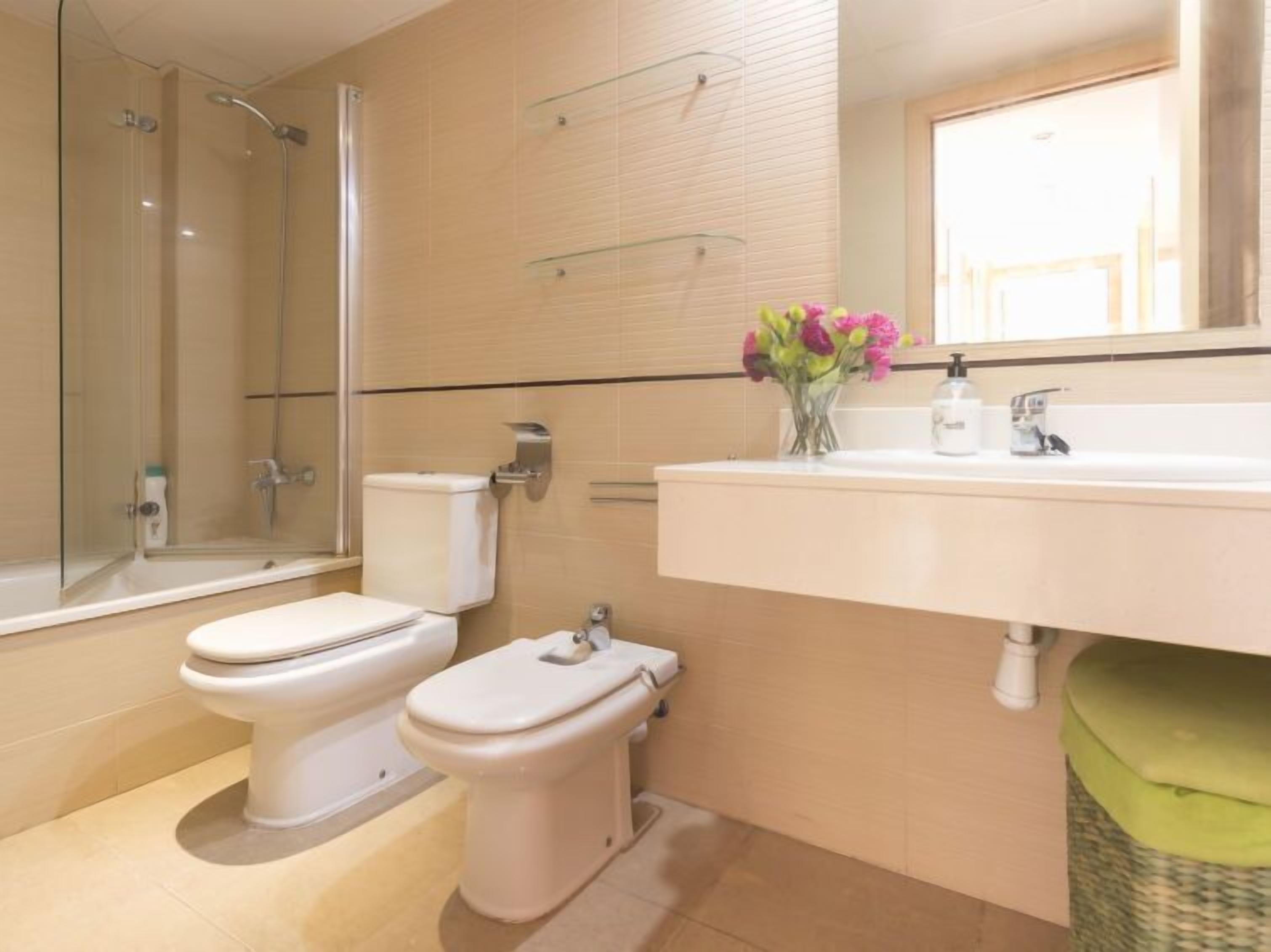 Un baño moderno con ducha, inodoro, bidé y un lavabo grande.