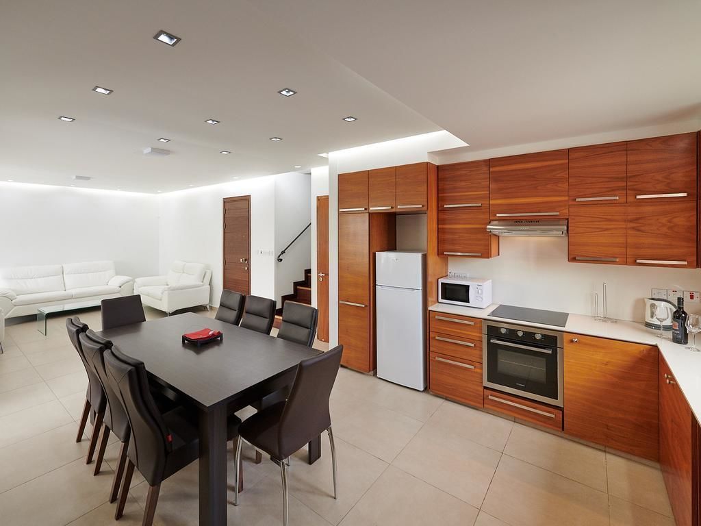 A modern kitchen with wooden cabinets, a built-in oven, and a microwave.