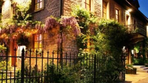 Un bâtiment en pierre avec une enseigne indiquant « Landgasthof der Brücke » la nuit.