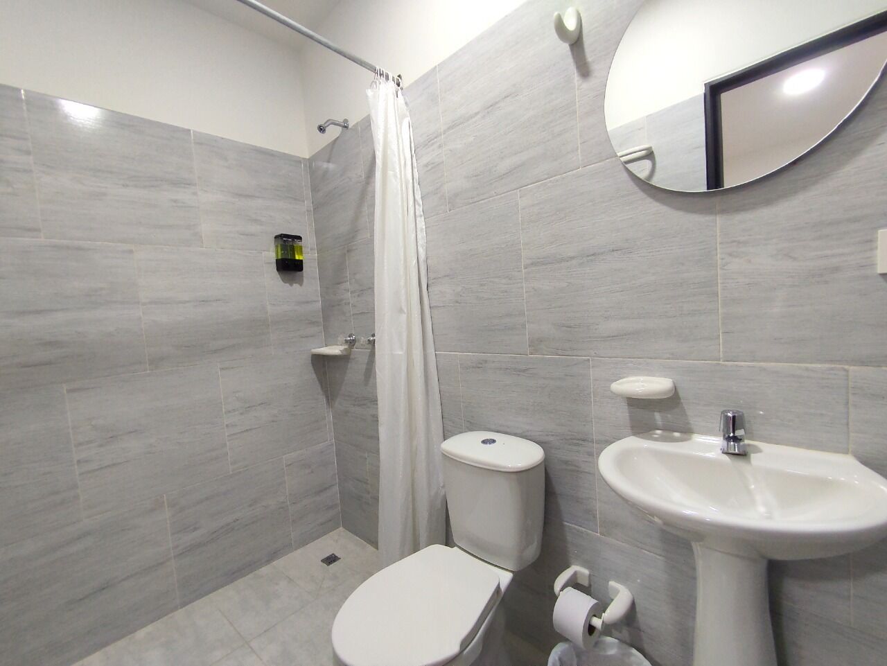 A bathroom with a shower, toilet, and sink.