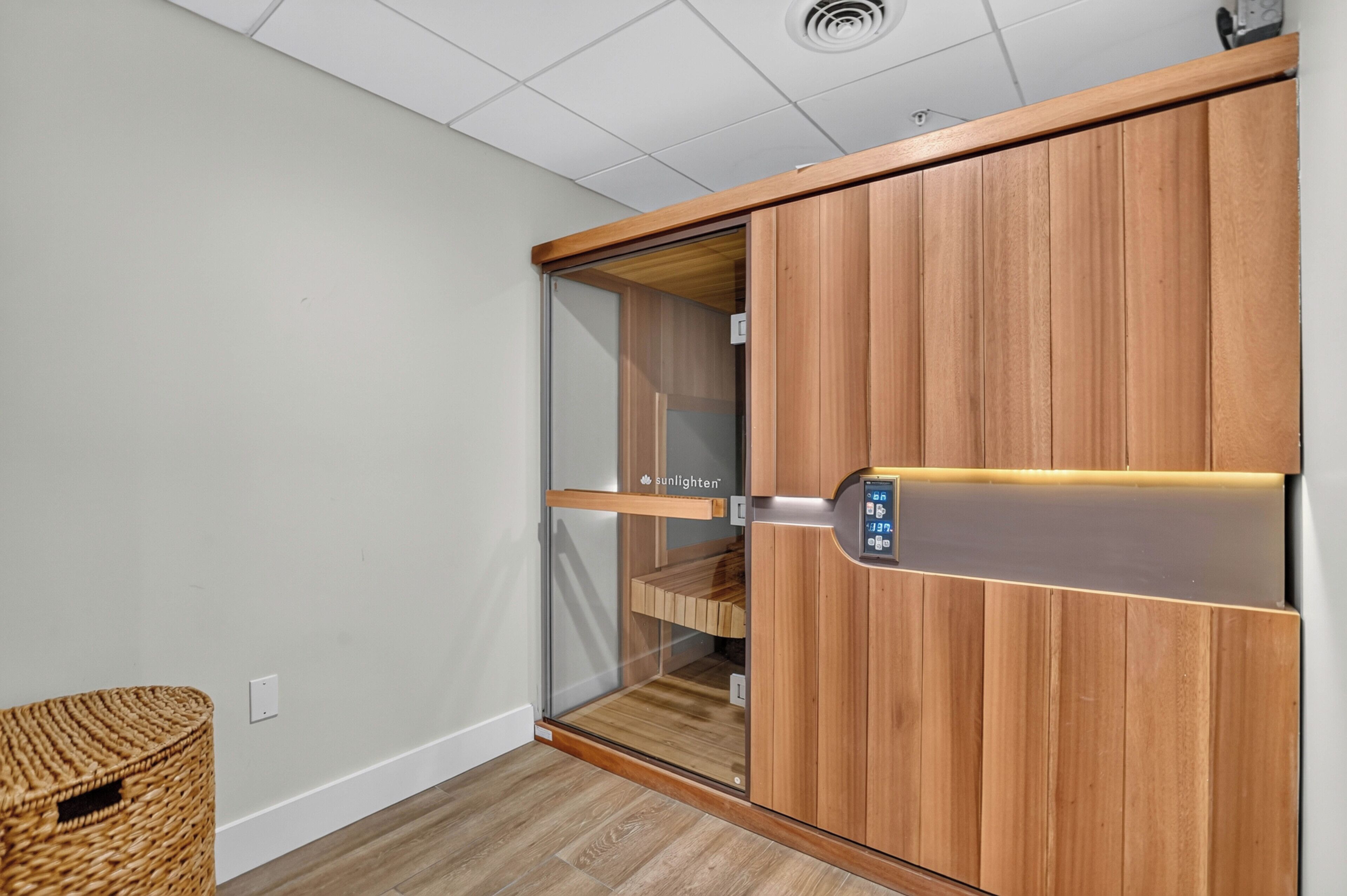 A room with a sliding wooden wardrobe, a glass door, and a woven basket.