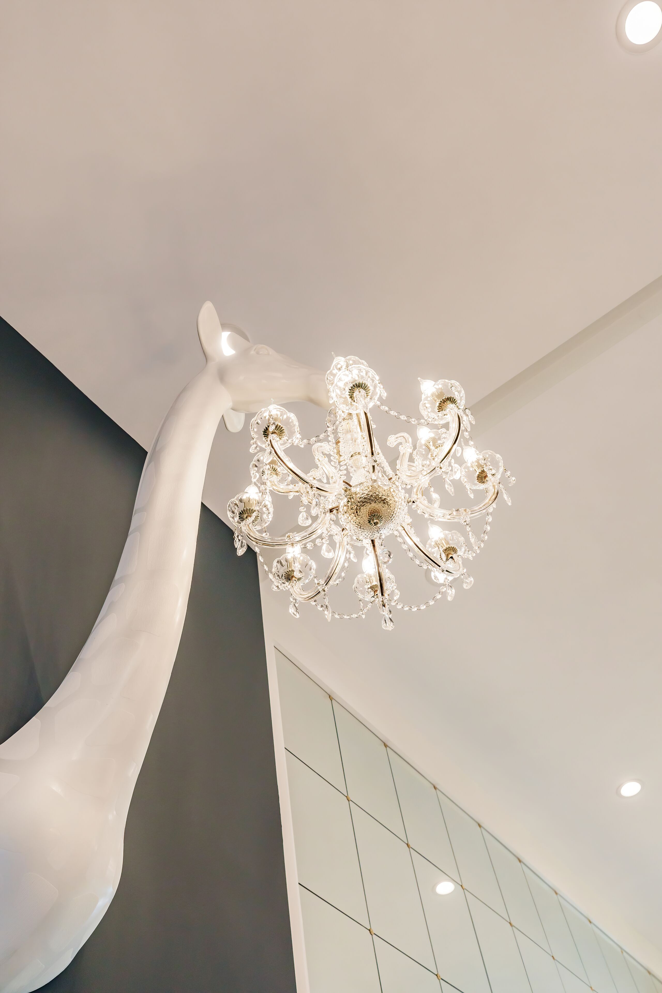 Un interior moderno con un elemento escultórico blanco único y una lámpara decorativa.