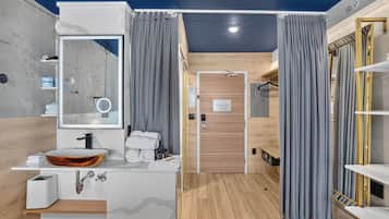 A modern bathroom with a large mirror, a vessel sink, and a wooden vanity.