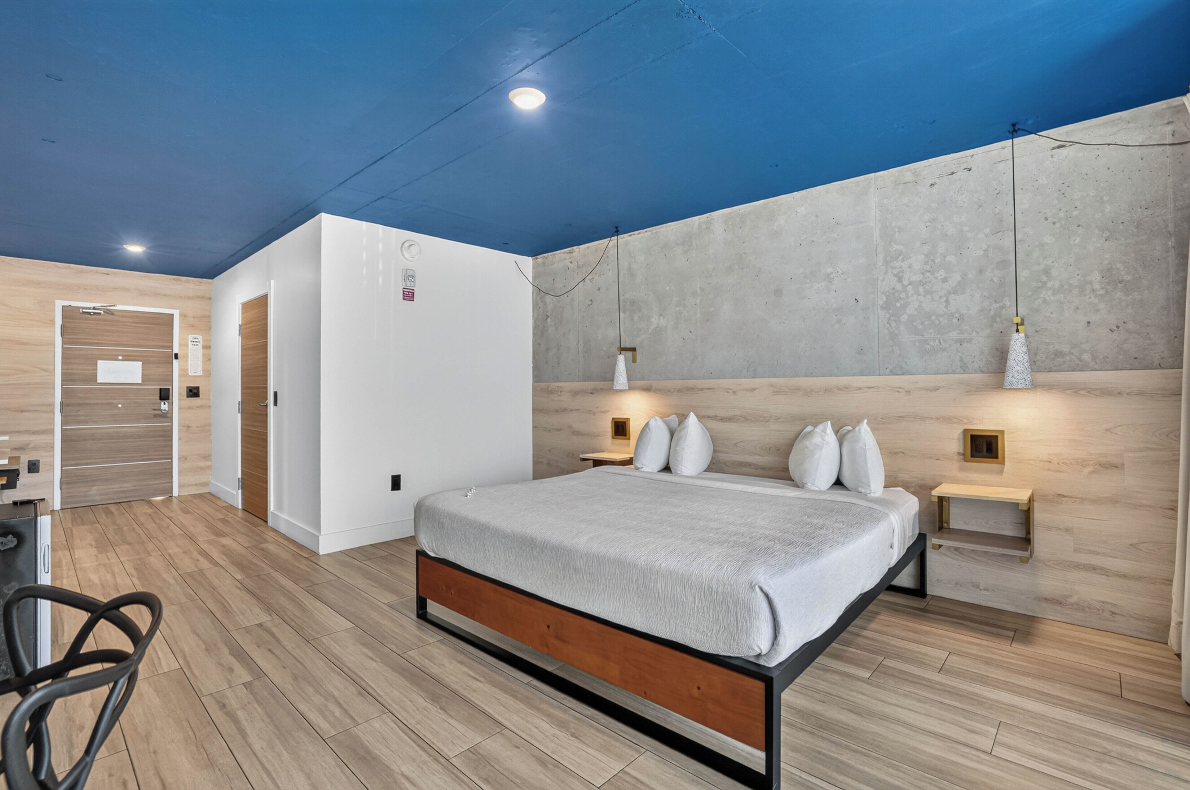 Un dormitorio moderno con cama, mesitas de noche y armario.