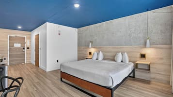 Un dormitorio moderno con cama, mesitas de noche y armario.