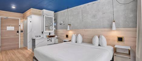 Un dormitorio moderno con una cama grande, un armario empotrado, un tocador con espejo y una mesita de noche.