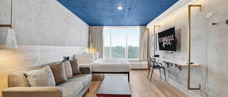 A modern living room with a sofa, a coffee table, and a television mounted on the wall.