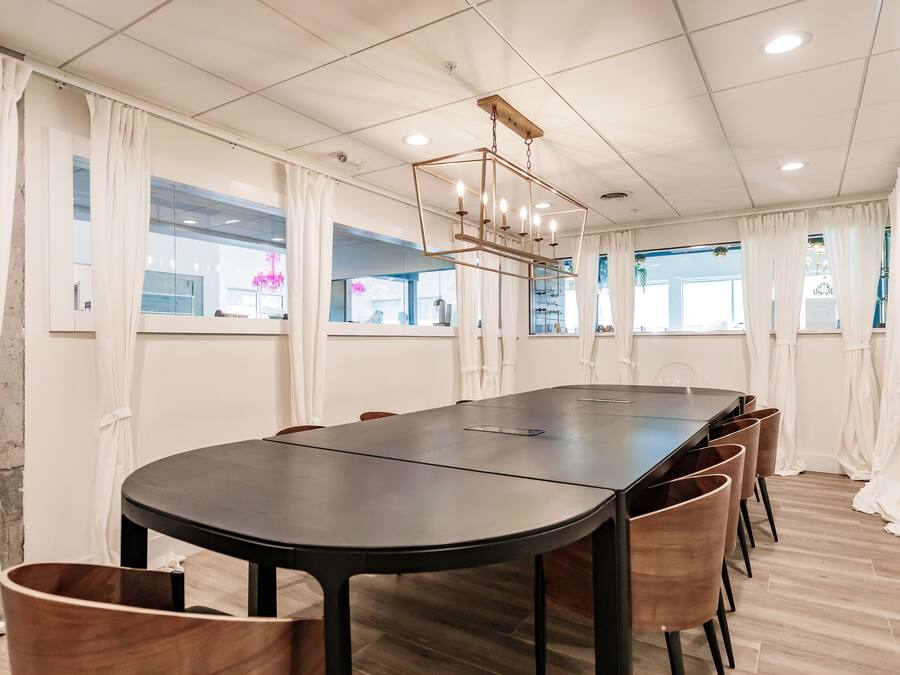 A conference room with a long table, chairs, and a chandelier.