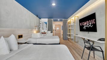Una habitación de hotel con cama, escritorio, televisor y espejo.