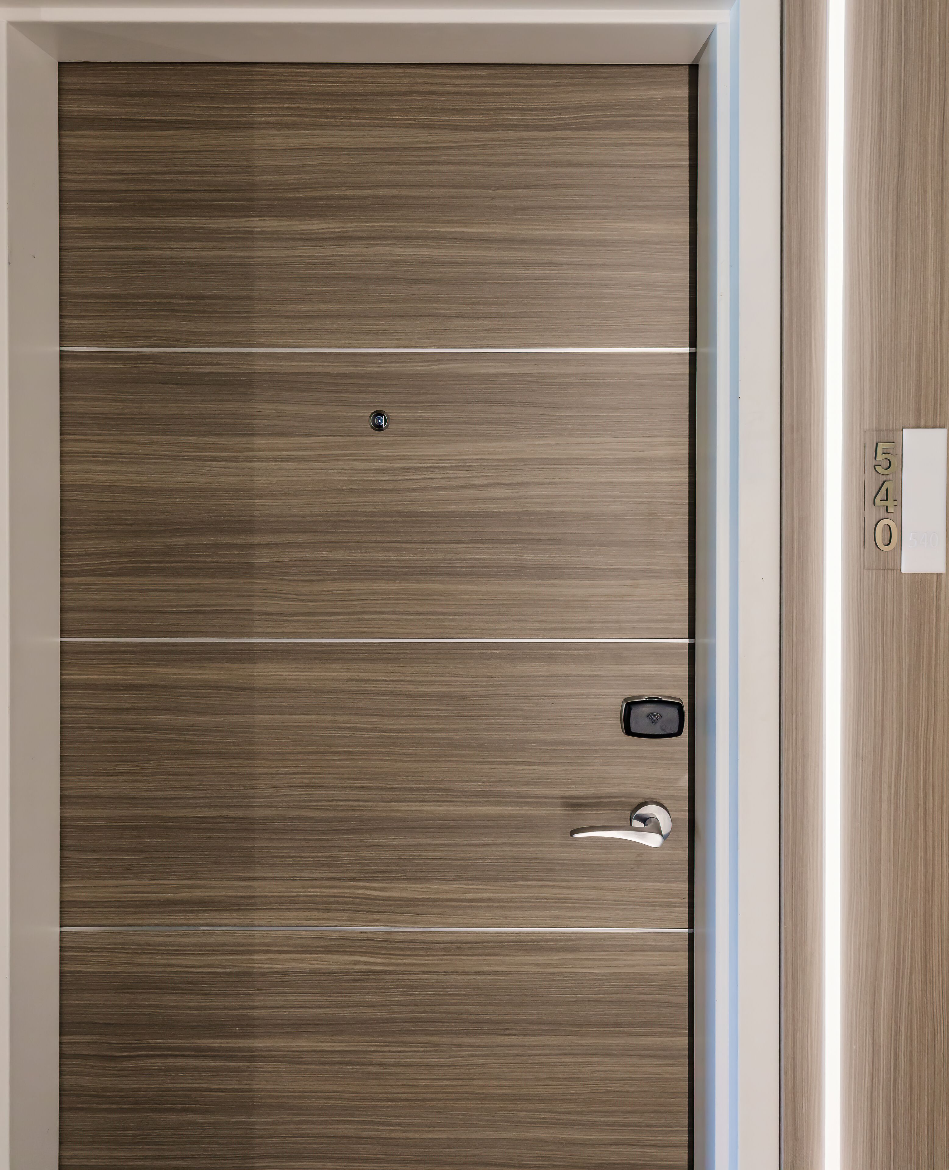 Una puerta con panel horizontal, mirilla y picaporte.