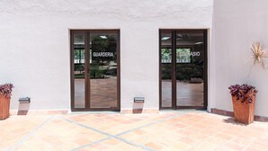 A building entrance with two glass doors labeled "GUARDERIA" and "SIMCASIO".