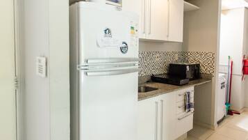 Departamento urbano | Cocina privada | Refrigerador con congelador, microondas, horno y parrilla de estufa