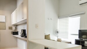 A modern kitchen with white cabinetry, a long countertop, and a built-in stove.
