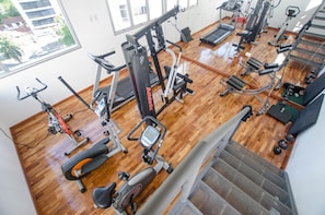 A gym with various exercise machines, a treadmill, and a stair stepper. - Manantiales Plaza Best Location in Asu (Asunción)