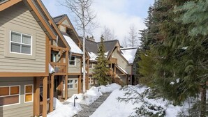 A row of wooden cabins with snow-covered roofs and a snow-covered pathway. - Overlooking Golf Course & Valley Trail, Parking (Whistler)
