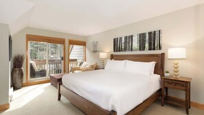 A bedroom with a large bed, a nightstand, a chair, a window, and a balcony. - Overlooking Golf Course & Valley Trail, Parking (Whistler)