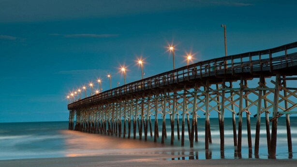 A pier extending into the water with lights along its length. - 3405 Champions Sunset Beach (Sunset Beach)