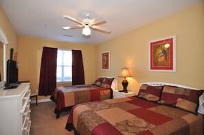 A hotel room with two beds, a ceiling fan, a desk with a lamp, and artwork on the walls. - 1402 Crow Creek Drive (Calabash)