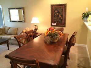 Enjoy meals with family and friends in this cozy dining area, complete with a table for four, comfortable seating, and a beautiful floral centerpiece.