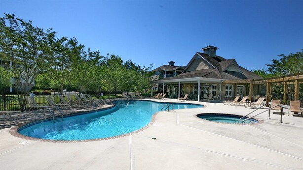 Uima-allas, jossa on aurinkotuoleja ja katettu terassi.