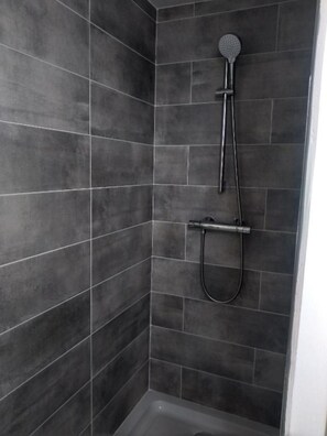Standaard kamer | Badkamer | Een douche, handdoeken, zeep, shampoo