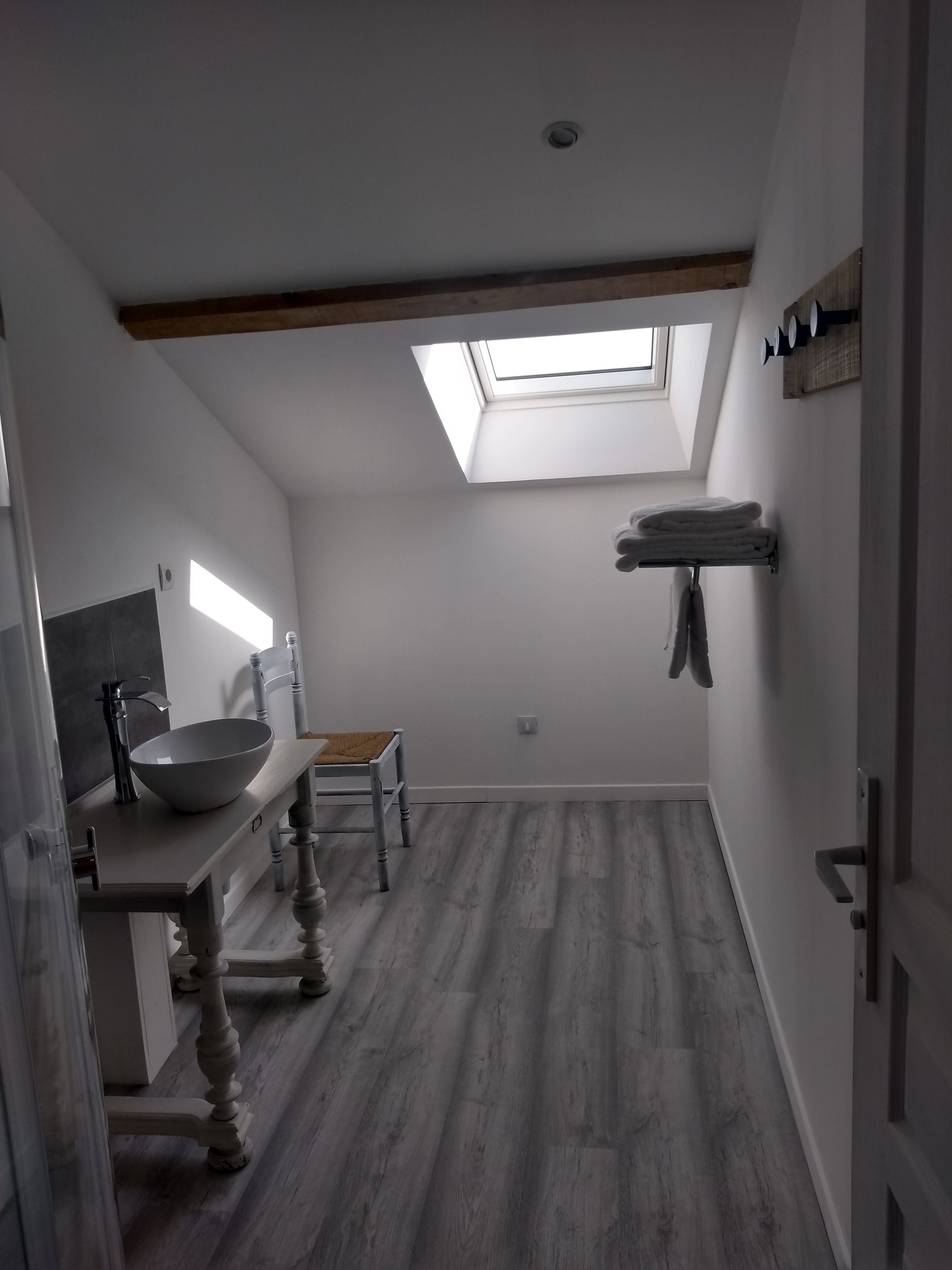 A compact kitchen with a skylight, a wooden dining table, and a built-in sink.
