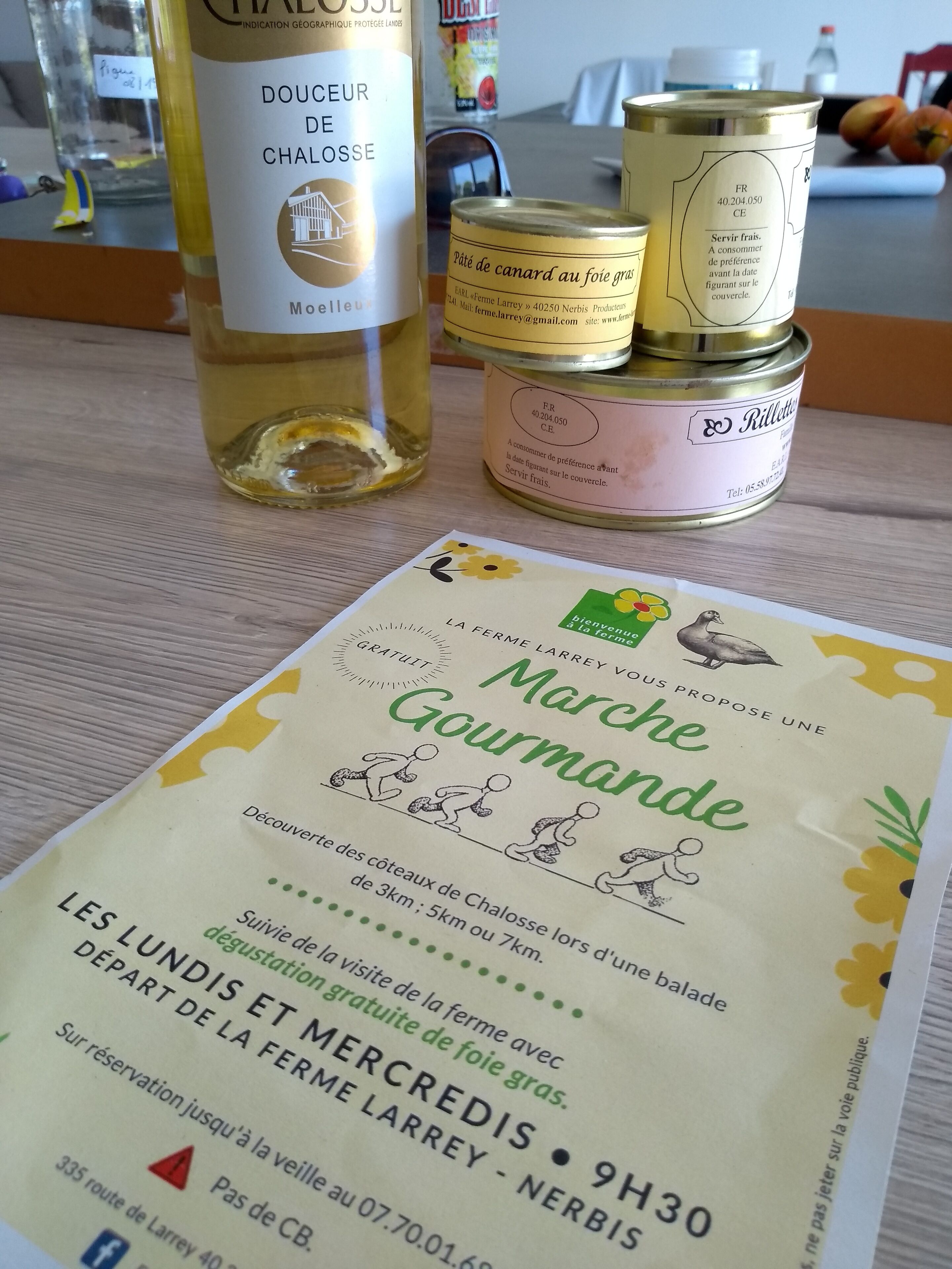 A menu with a can of canned food and a bottle of oil on a table.