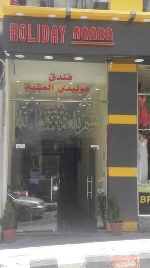 A storefront with a sign reading "HOLIDAY AOABA" and Arabic script above the entrance. - Holiday aqaba hotel (Aqaba)