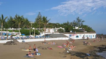 In Strandnähe, weißer Sandstrand, Liegestühle, Sonnenschirme