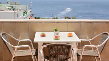 Enjoy ocean views from this balcony with a table and chairs, perfect for a morning coffee or a relaxing moment.