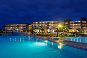 A modern hotel with a swimming pool, multiple balconies, and outdoor seating areas. - Altos del Arapey Club de Golf & Hotel Termal (Termas del Arapey)