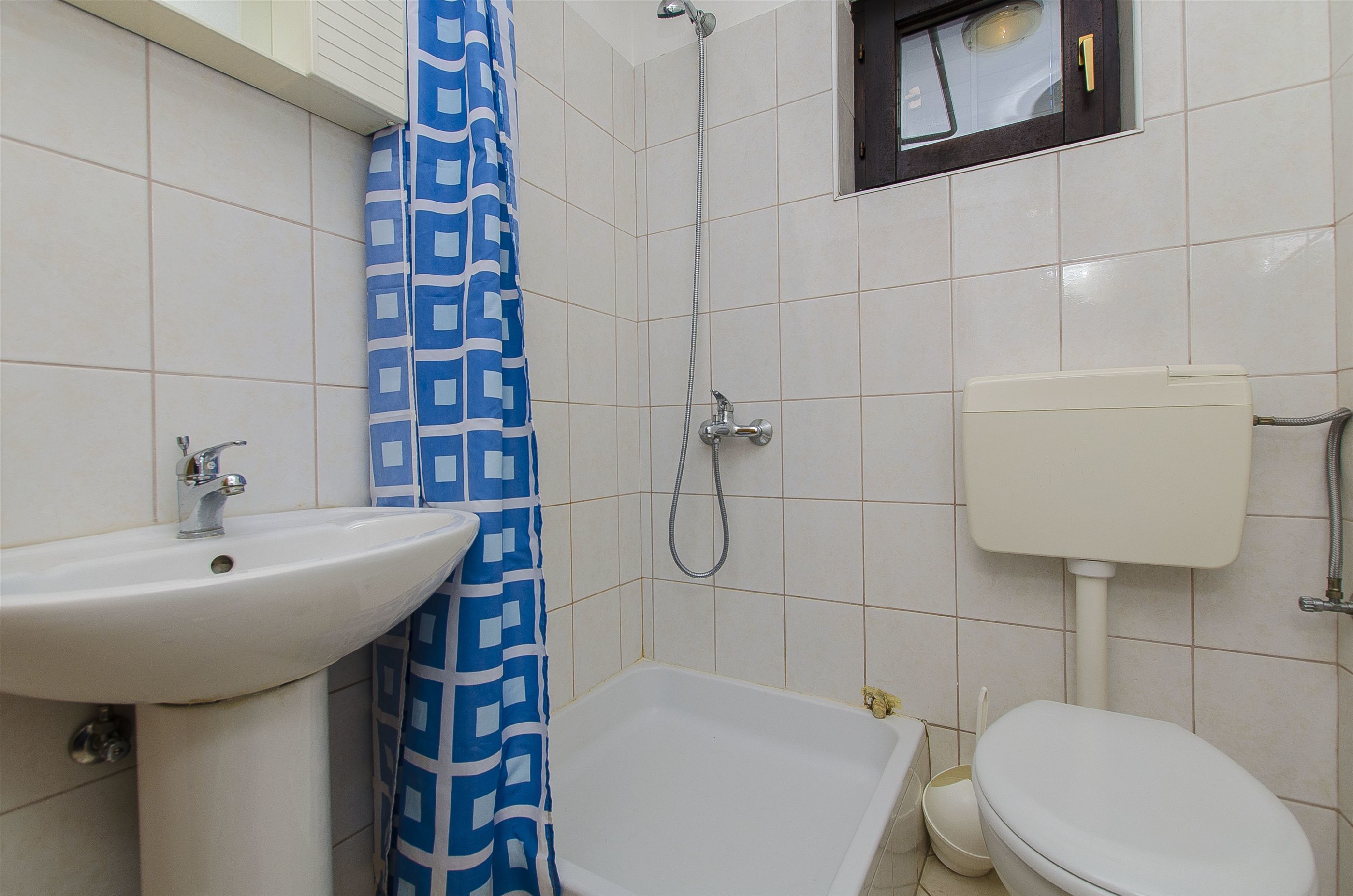 A bathroom with a white sink, a bathtub, and a toilet.