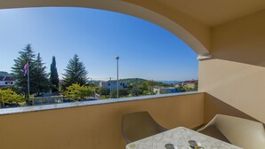 Un balcon avec une table et des chaises, une vue dégagée sur les environs et un drapeau.