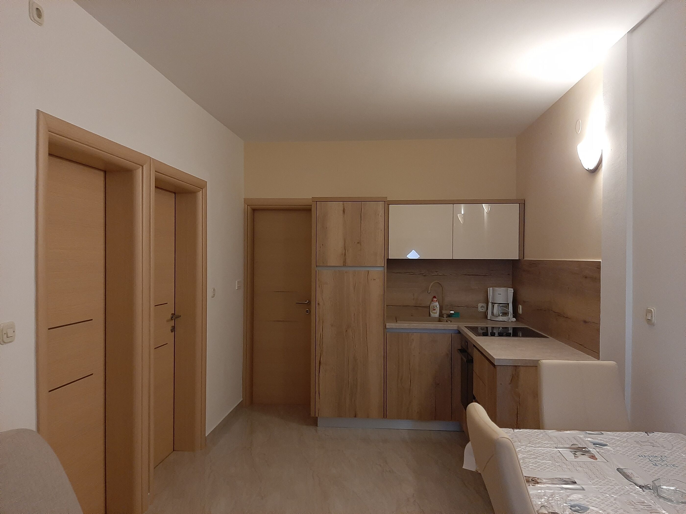 Eine kompakte Küche mit Holzausstattung, einem Spülbecken und einer kleinen Essecke mit Tisch.