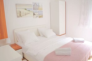 A neatly arranged bedroom with a bed, bedside table, and a wall-mounted artwork.