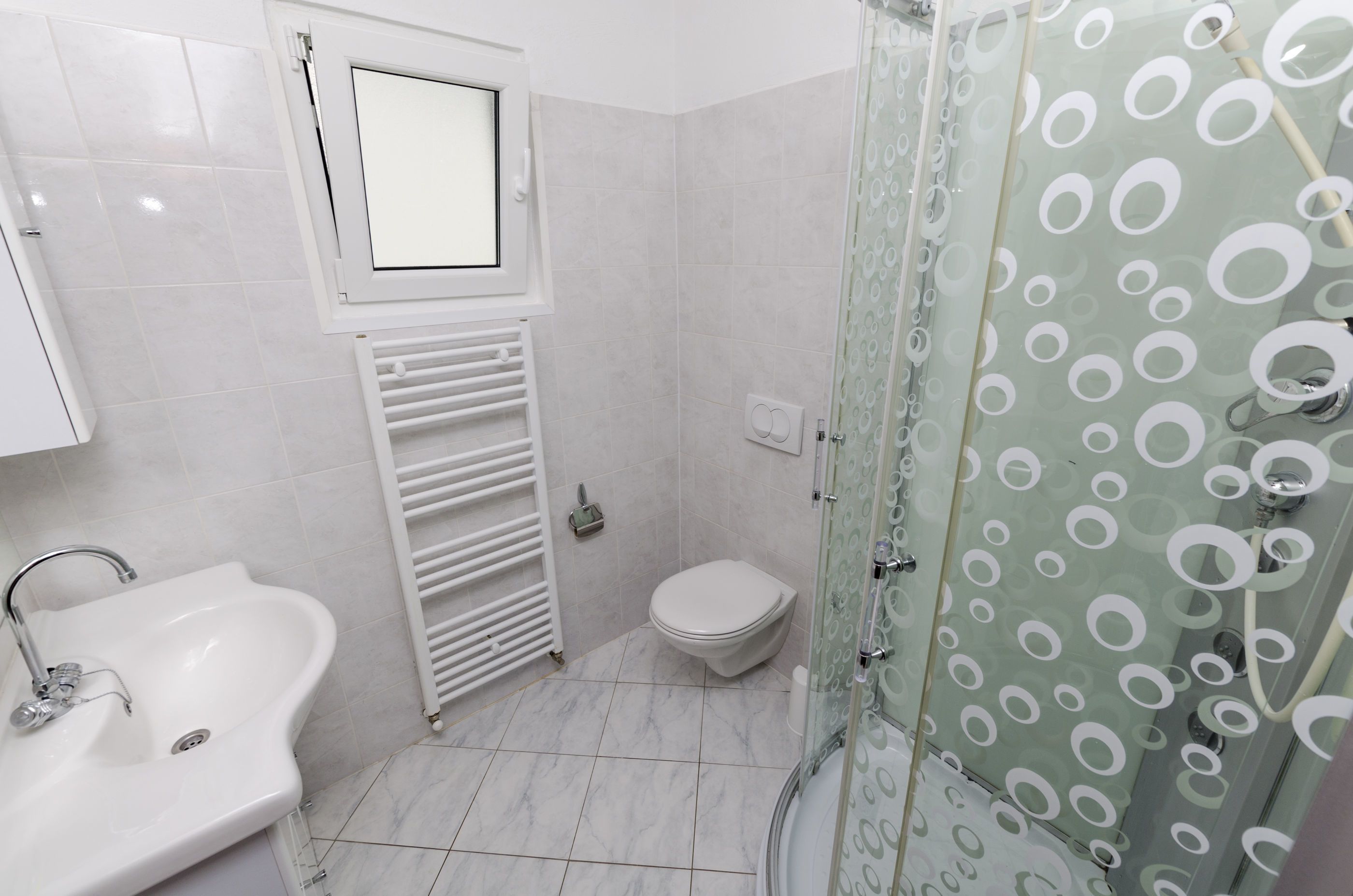Une salle de bain avec un lavabo, des toilettes et une douche.