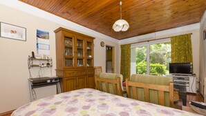 A bedroom with a bed, wooden headboard, a TV, and a window with curtains. - Apartments Luka (Rogoznica)