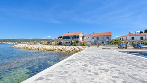 A coastal promenade with stone paving, waterfront properties, and clear blue skies. - Apartments Marica (Sukosan)