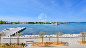 A waterfront promenade with a dock, benches, and a clear view of the sea. - Apartments Marica (Sukosan)