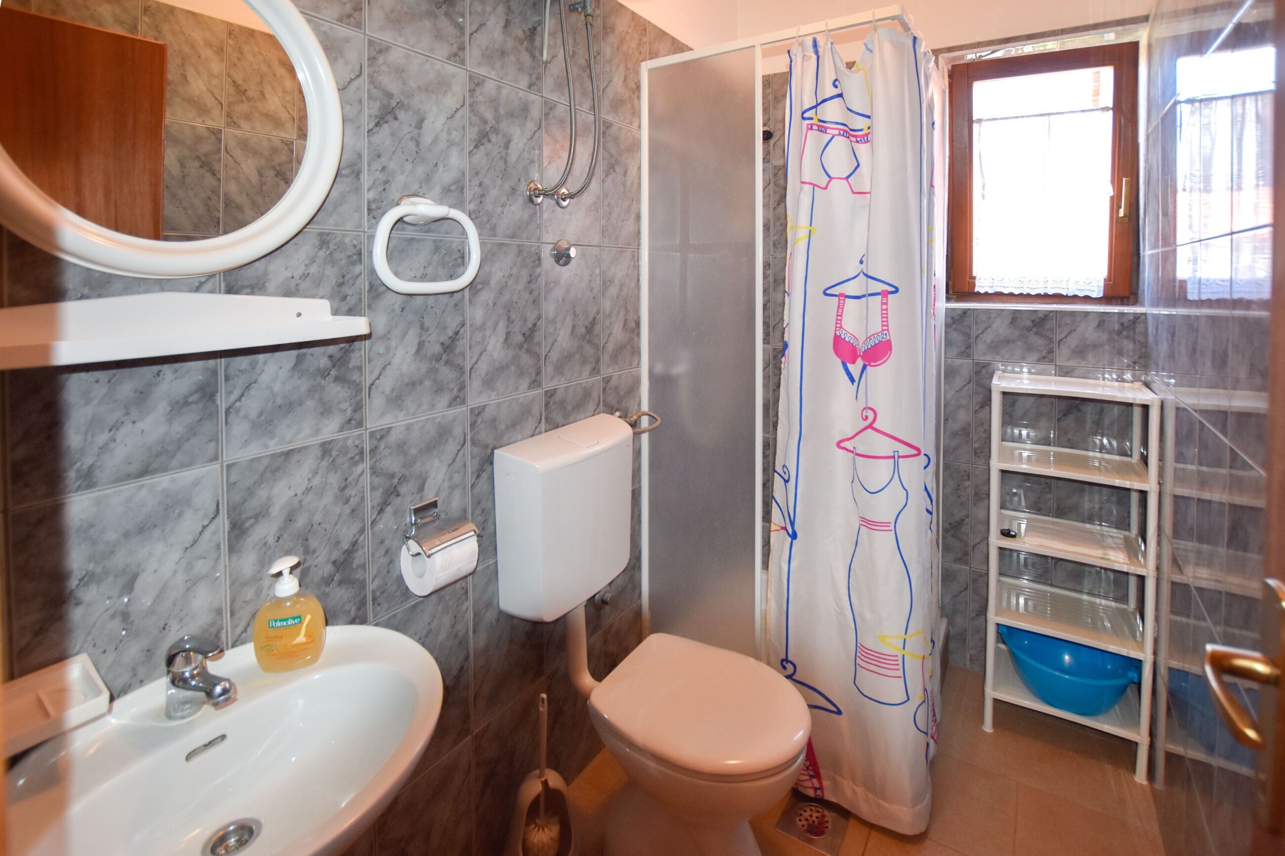 A bathroom with a toilet, sink, and shower.