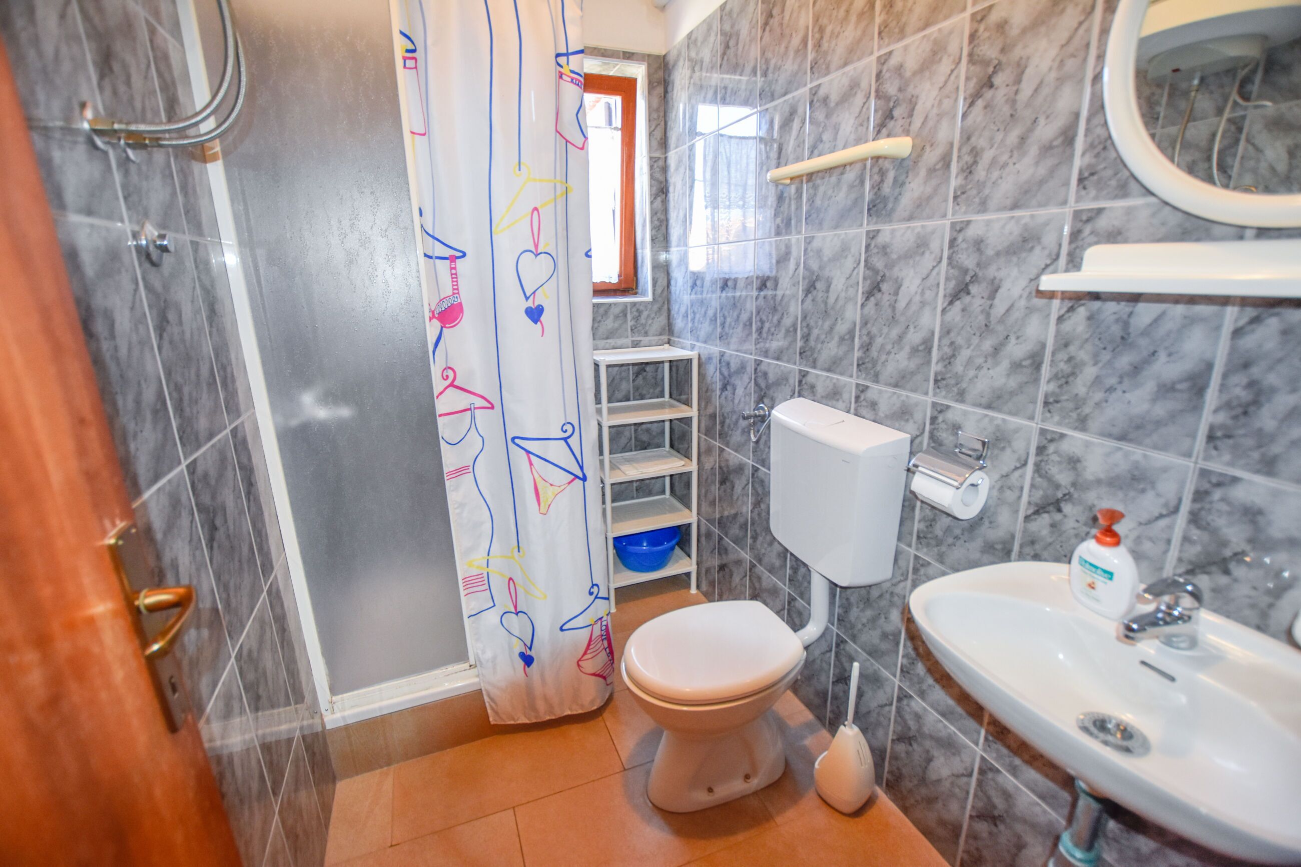 A bathroom with a toilet, sink, and shower area.