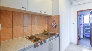 A kitchen with a stove, sink, and cabinets. - Apartments Marica (Sukosan)